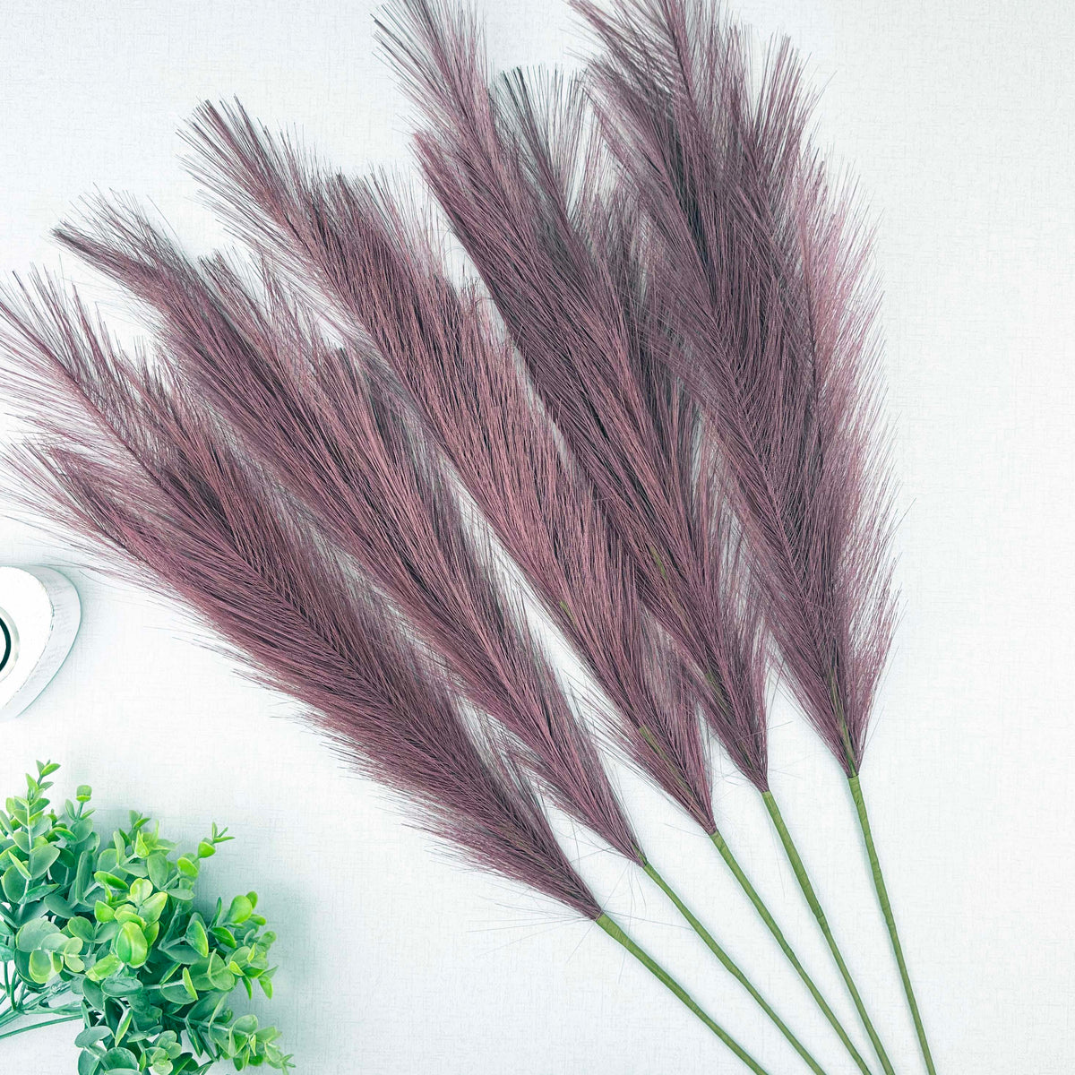 Scarlet Red Faux Pampas Grass Stems with a heart tealight holder and greenery, on a white background.