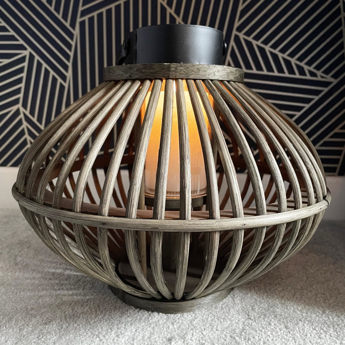 Bamboo Style Candle Lantern with candle lit, on a navy and gold background