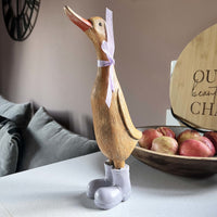 Darcey Duck on kitchen bench with fruit bowl full of apples in behind her