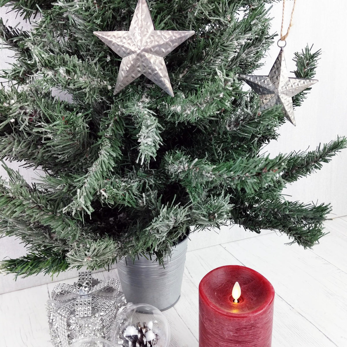 Decorative Metal Hanging Star on Christmas Tree with candle and present