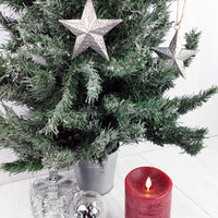 Decorative Metal Hanging Star on Christmas Tree with candle and present