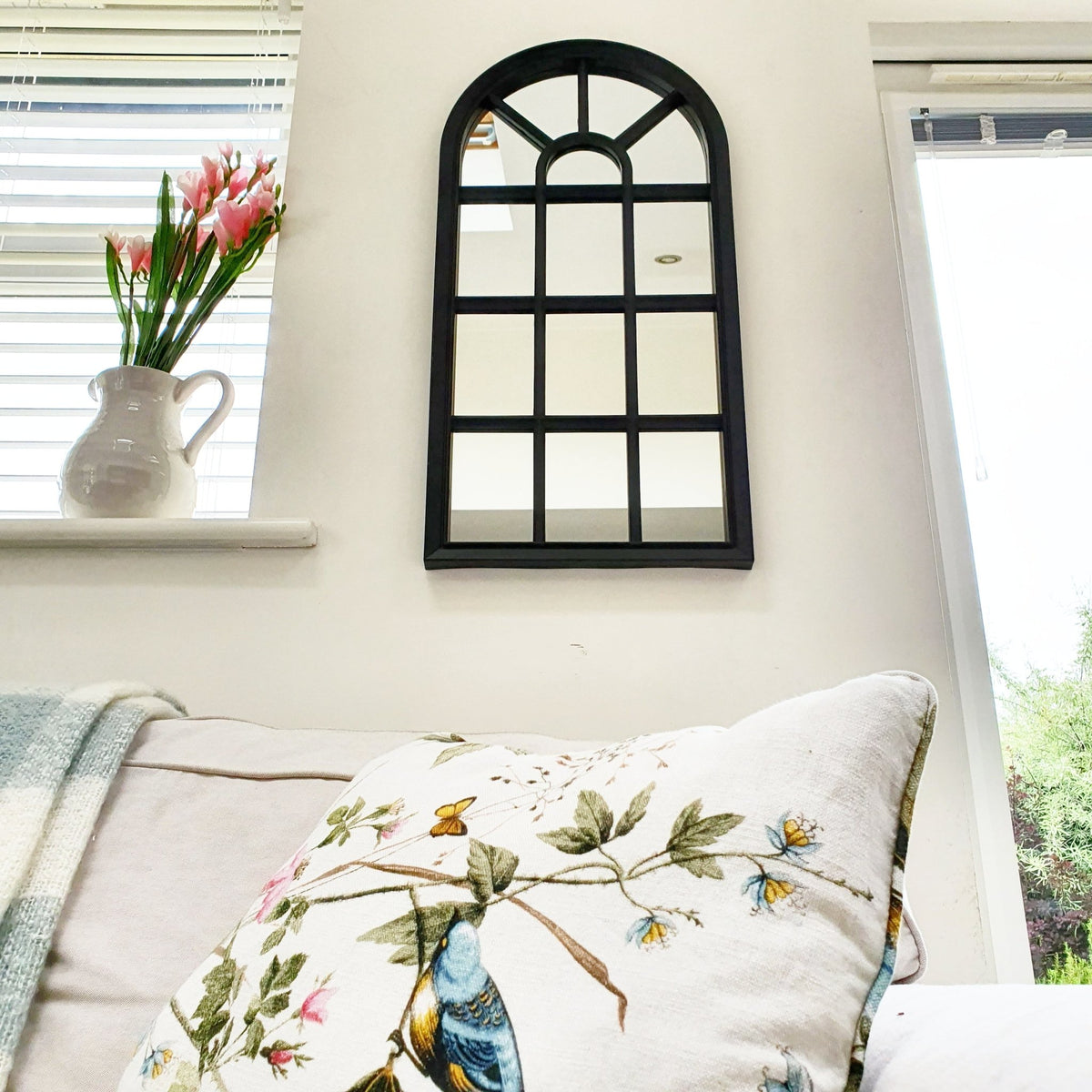 Velit Window style wall mirror in black on white kitchen wall with pink flowers on windowsill