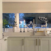 Modern kitchen with white cabinets, a sink, and decorative elements.