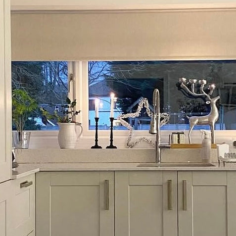 Modern kitchen with white cabinets, a sink, and decorative elements.