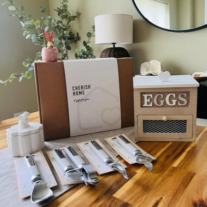 Decorative items including a 'Cherish Home' box, kitchen tools, and an 'Eggs' container on a wooden surface.