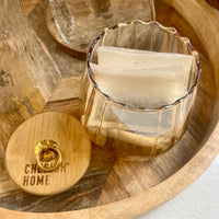 Clear glass container with tea bags on a wooden surface, featuring 'Cheeky Home' branding.