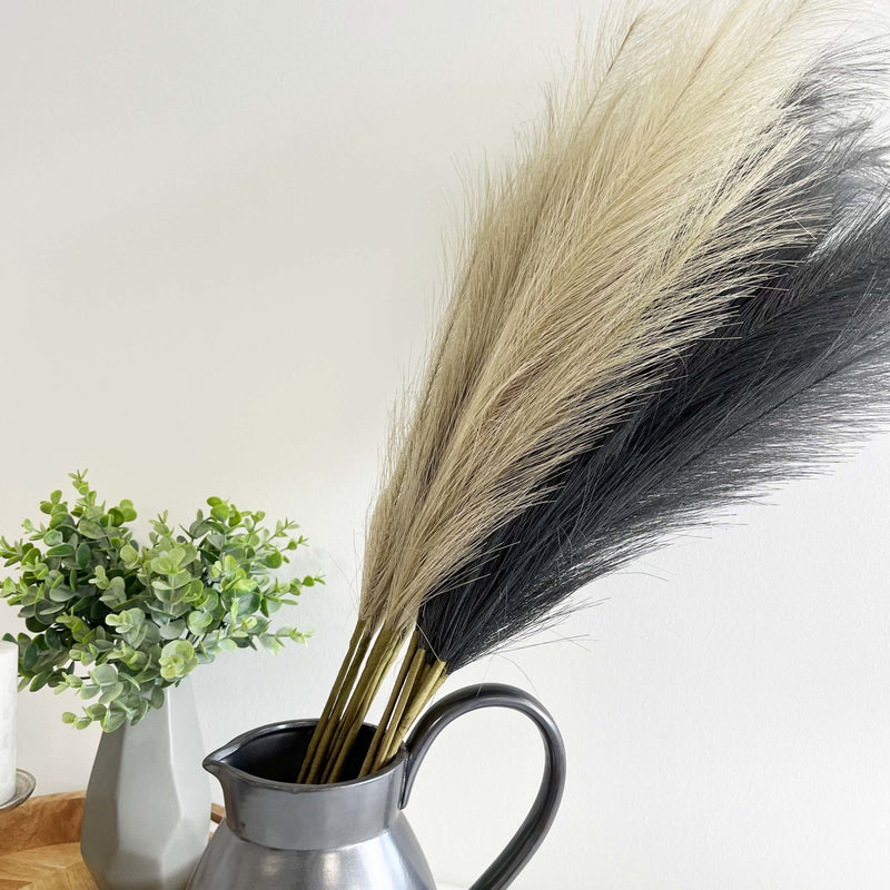 Bleached Faux Pampas Grass Stems with black faux pampas stems in grey jar with greenery.