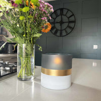 Contra Frosted Glass Votive Candle Holder on kitchen bench with fresh flowers and clock on the wall behind