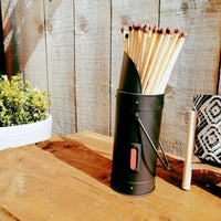 Cute Metal Match Stick Holder in black, next to planter and black and white candle