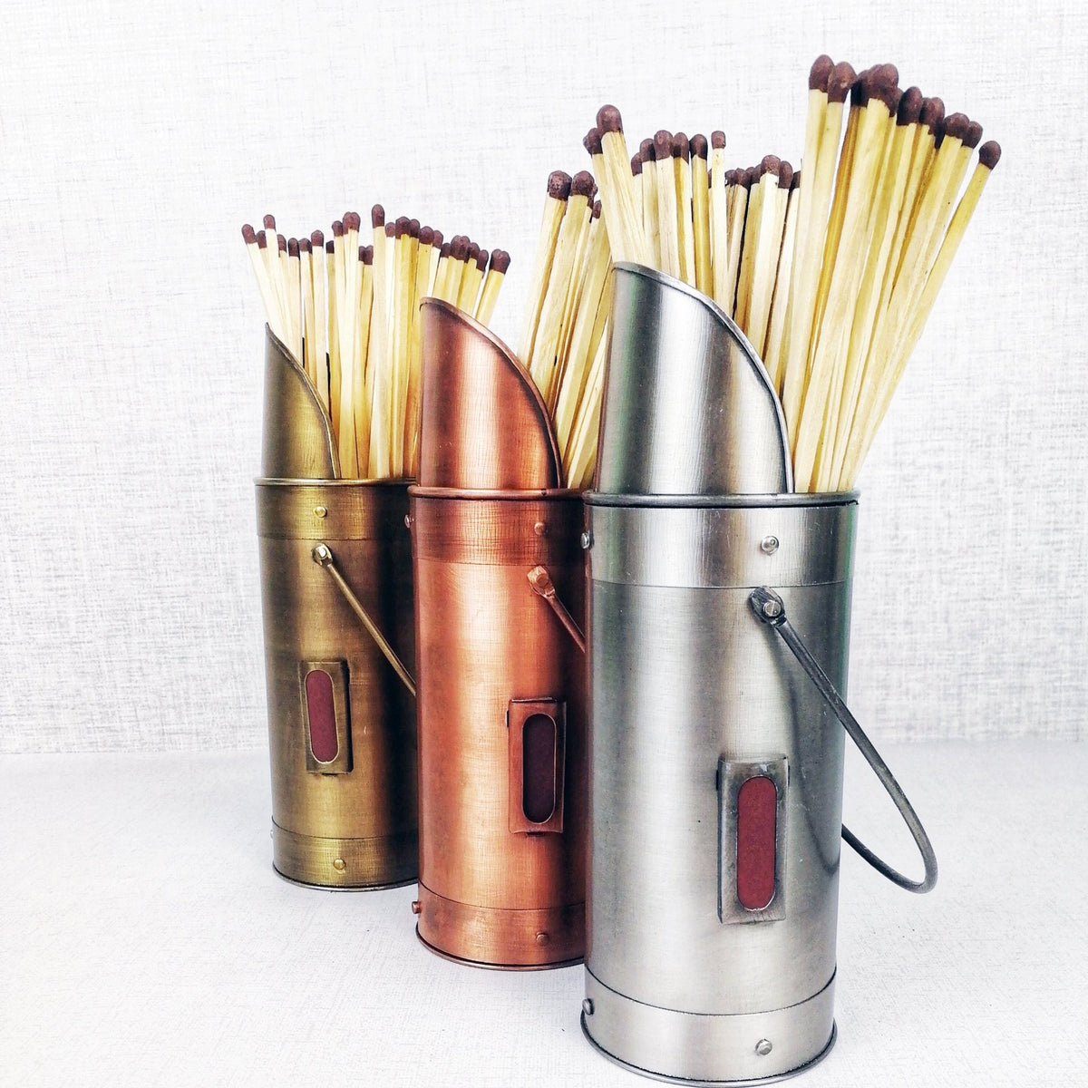 Matchstick holders bronze pewter copper against grey background