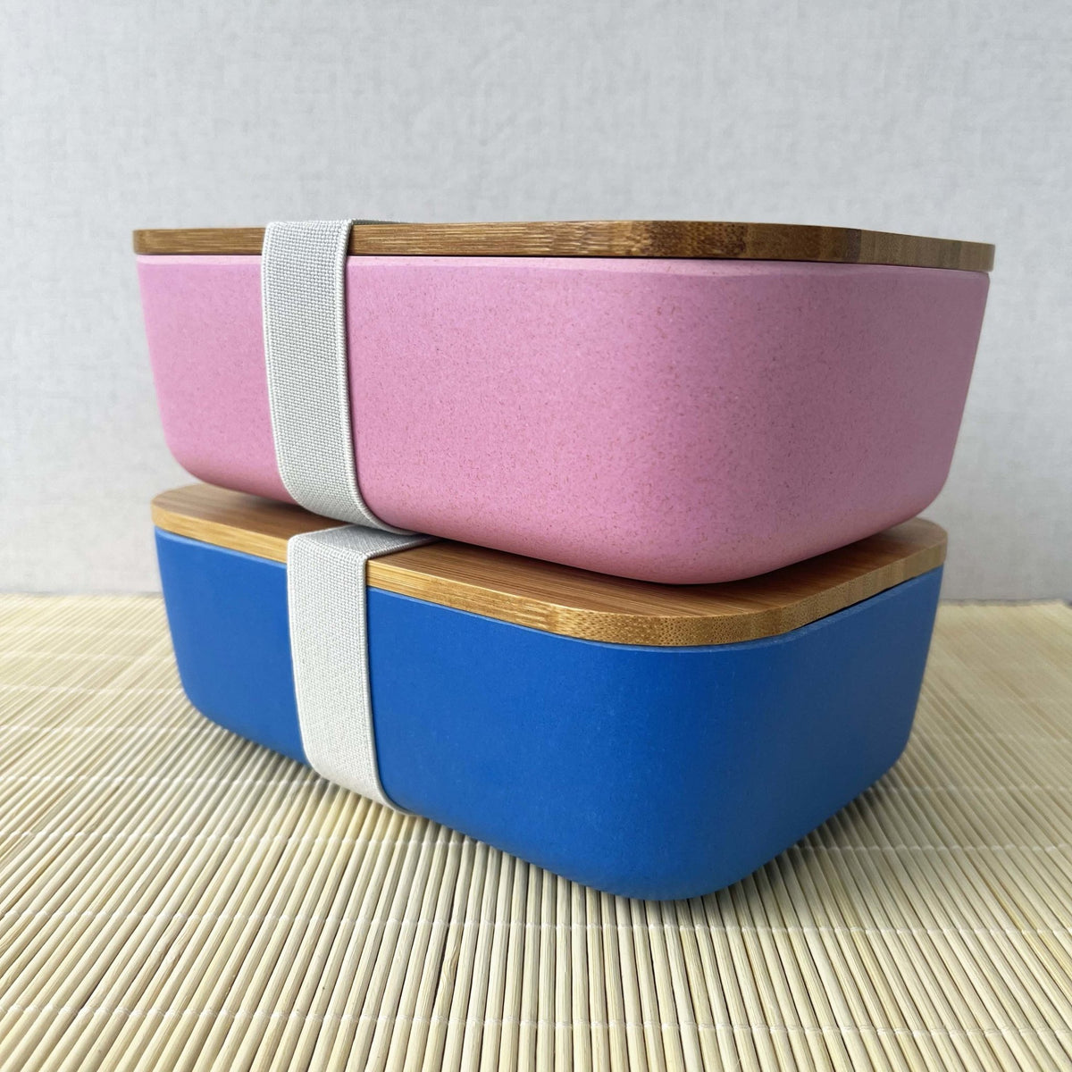 Blue and pink Eco Bamboo & Wheat Fibre Lunch / Bento Box, stacked on top on each other, on white background