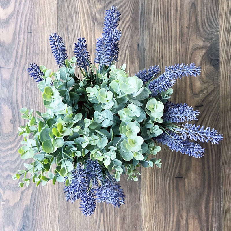 Full leaf sprays with lavender on a wood background.