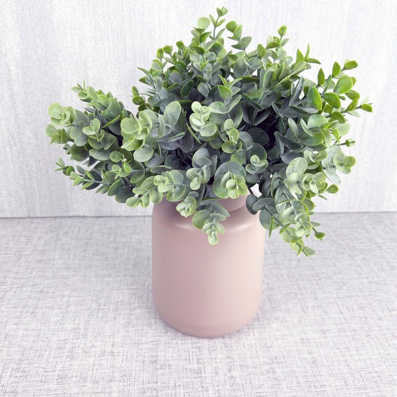 Full leaf sprays in pink vase on grey background.