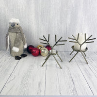 Gold Reindeer Candle Holder Set with gold and red baubles, with our penguin friend