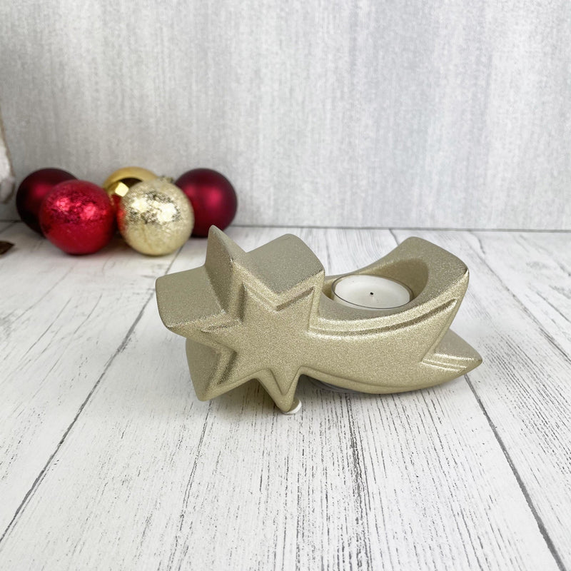 Gold star tea light candle holder with lit candle