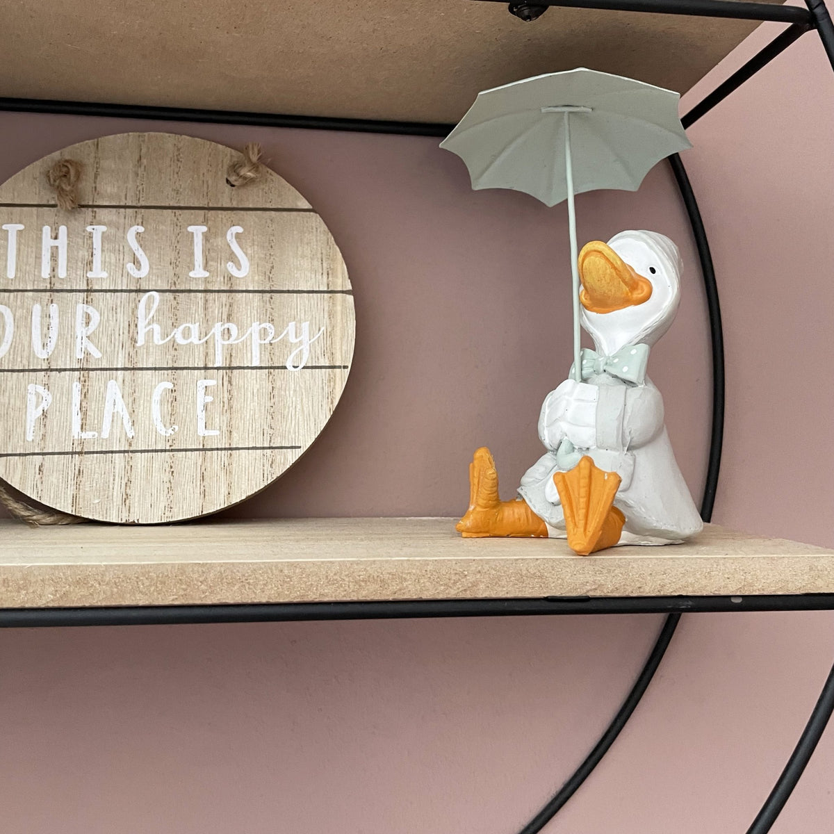 Happy Rainy Ducks ornament sat on shelving with wood sign saying this is our happy place. 