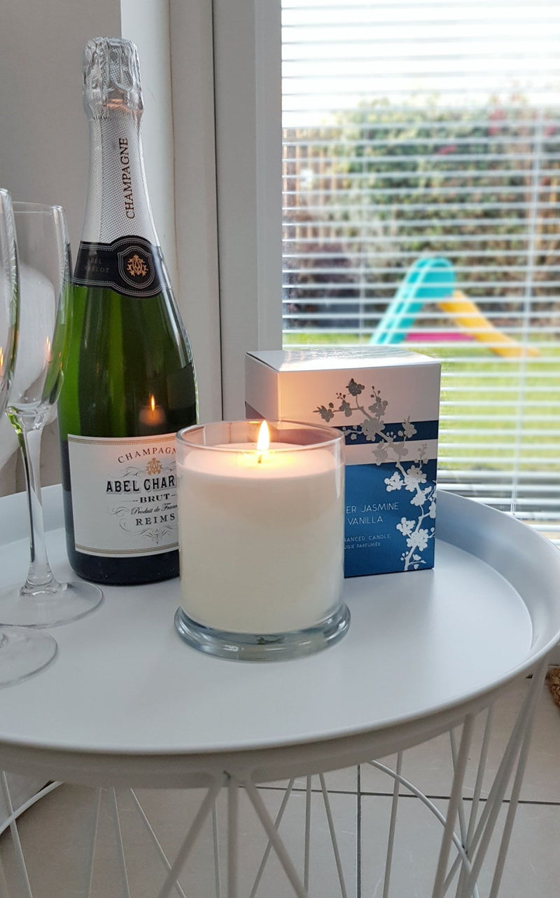 Winter Jasmine and Vanilla Christmas Candle on white table with champagne