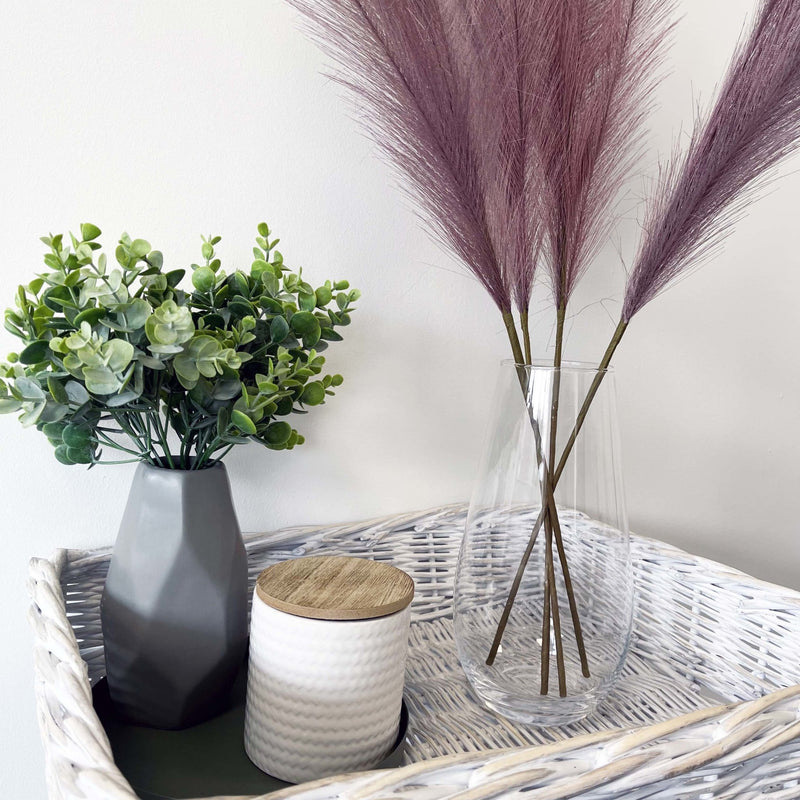 Lilac Faux Pampas Grass Stem in glass  vase with plant and candle.