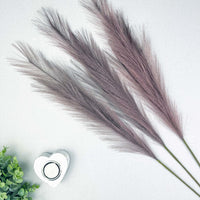 Lilac Faux Pampas Grass Stems with white heart tealight holder and greenery.