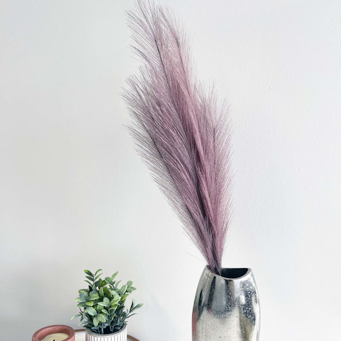 Lilac Faux Pampas Grass Stem in chrome vase with plant. 