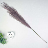 Lilac Faux Pampas Grass Stem on white background with white heart tealight and greenery.