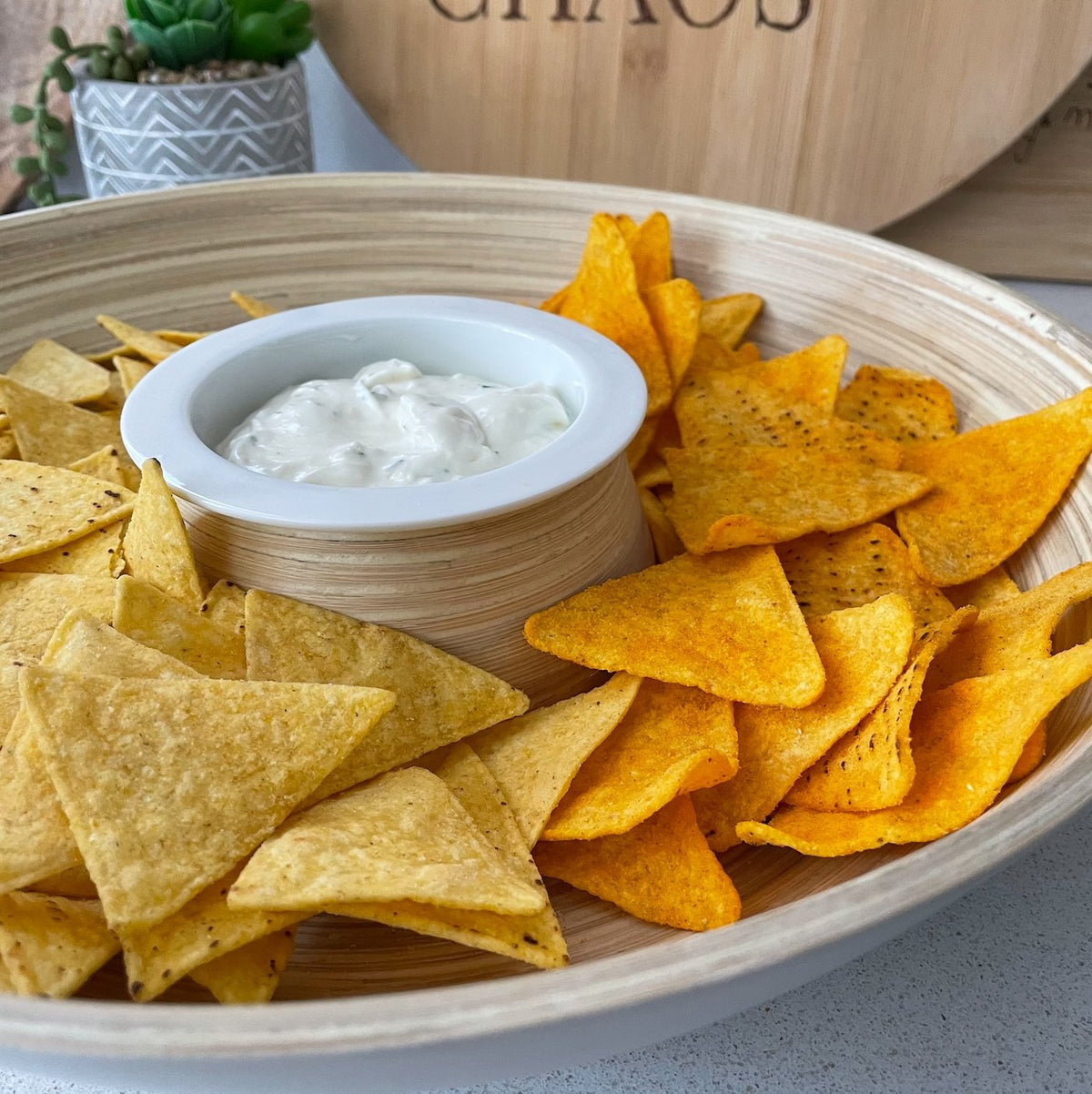 Bamboo Chip 'n' Dip bowl filled with doritos crisps and dip, on kitchen bench top