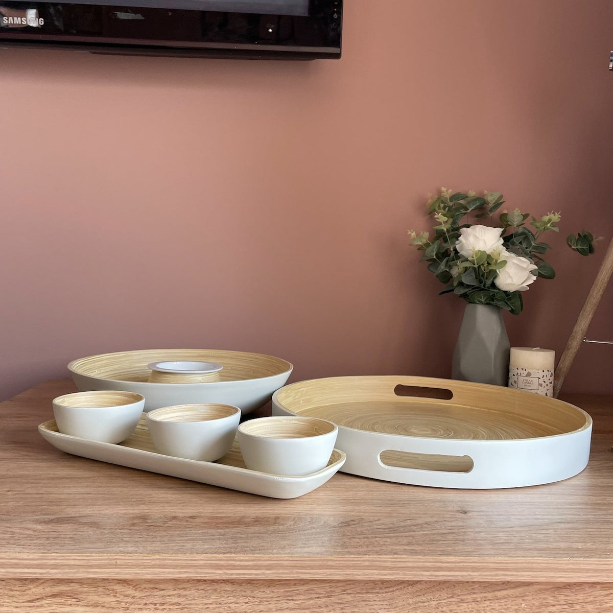 Bamboo Chip 'n' Dip bowl collection of serving trays and snack bowls on a table with a grey vase plant and a pillar candle