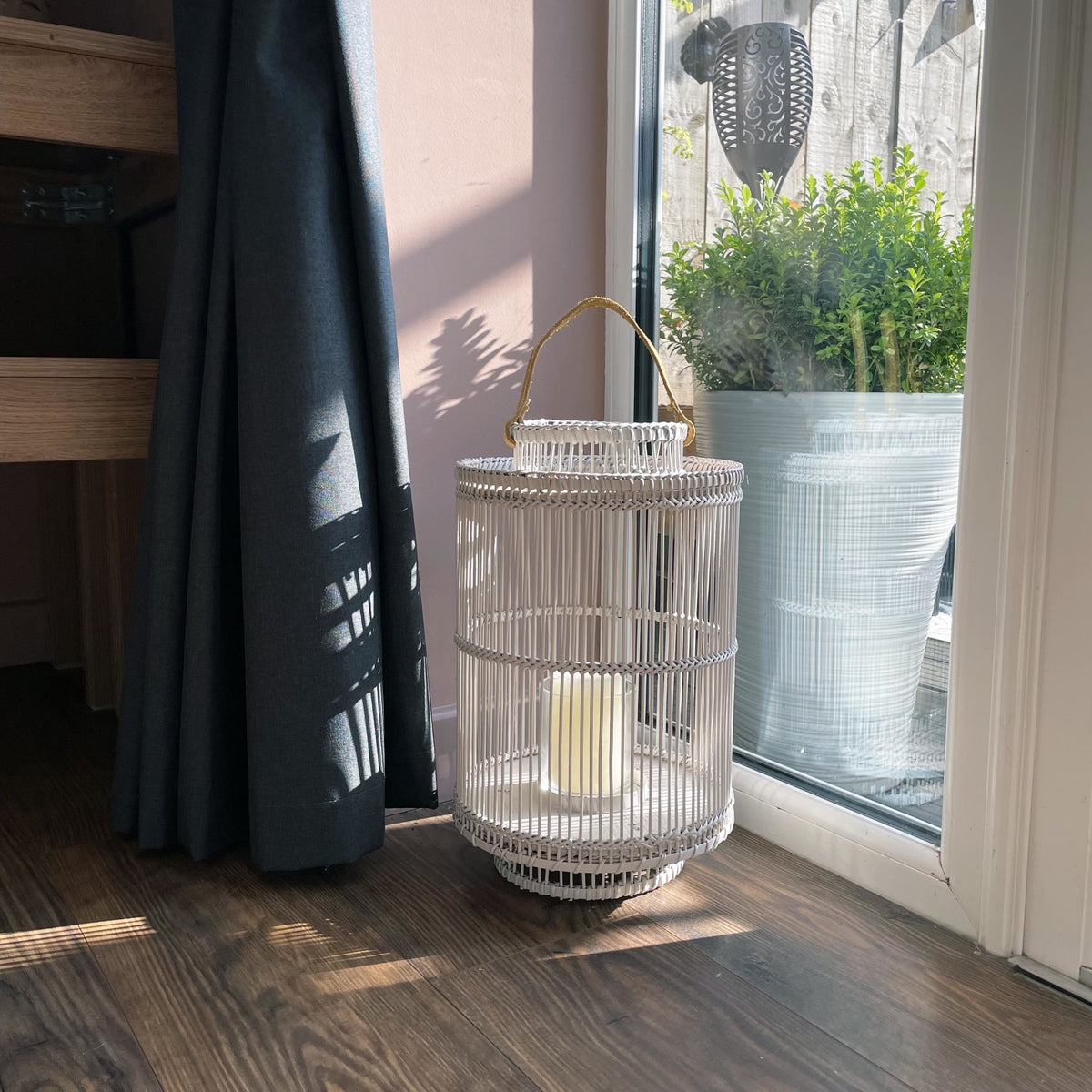 Usiku Bamboo Lantern in grey in a kitchen on a wooden floor with a planter behind